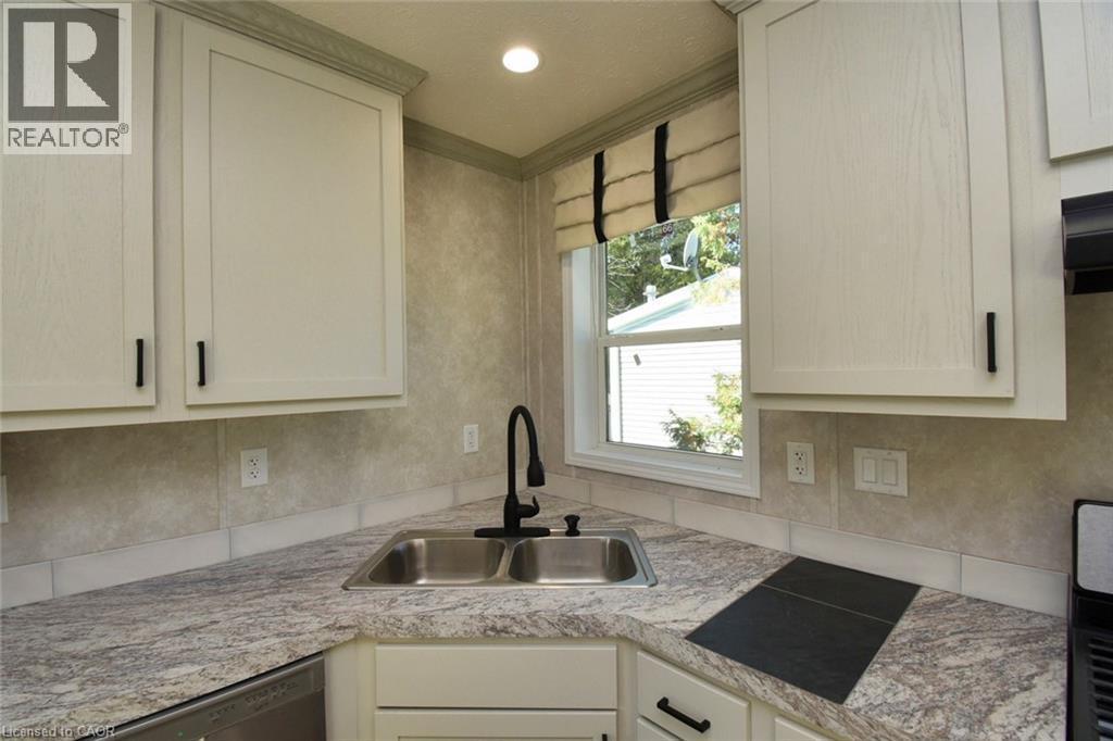 Kitchen featuring light countertops, stainless steel dishwasher, and ornamental molding - 1085 Concession 10 Road W Unit# 23, Flamborough, ON - Indoor Photo Showing Kitchen With Double Sink