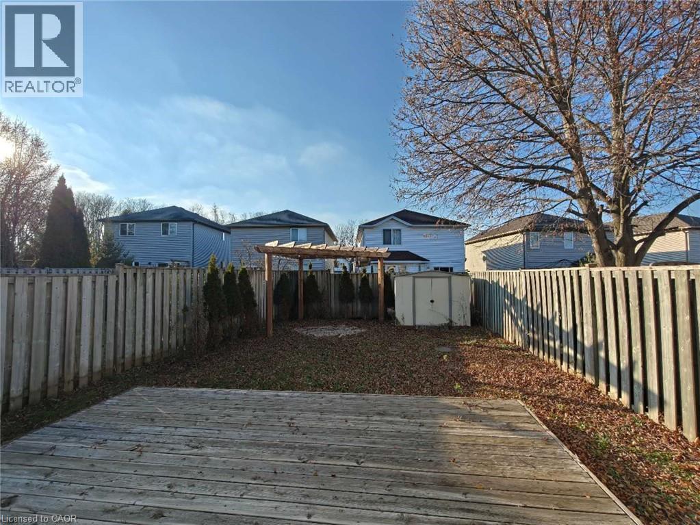 Wooden deck with a fenced backyard, a shed, and a residential view - 563 Dansbury Drive, Waterloo, ON