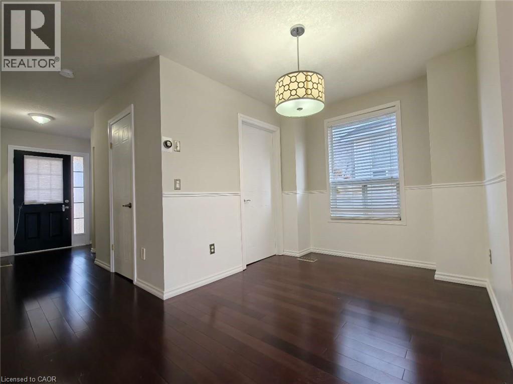 Unfurnished dining area featuring healthy amount of natural light and dark wood-style floors - 563 Dansbury Drive, Waterloo, ON