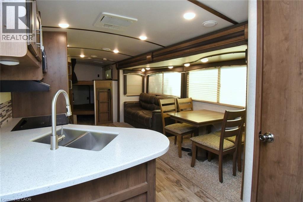 Kitchen with light stone counters, light wood-style floors, dark brown cabinetry, and open floor plan - 1085 10Th Concession Road W Unit# 29, Flamborough, ON - Indoor