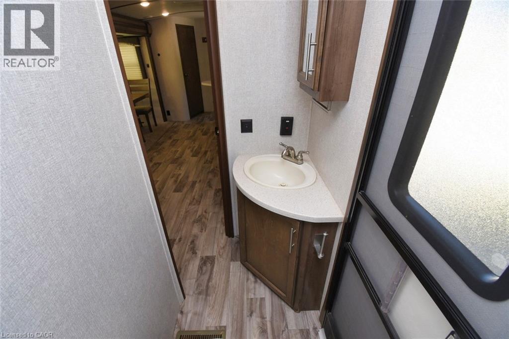 Half bathroom featuring light wood finished floors, vanity, and a textured wall - 1085 10Th Concession Road W Unit# 29, Flamborough, ON - Indoor Photo Showing Bathroom