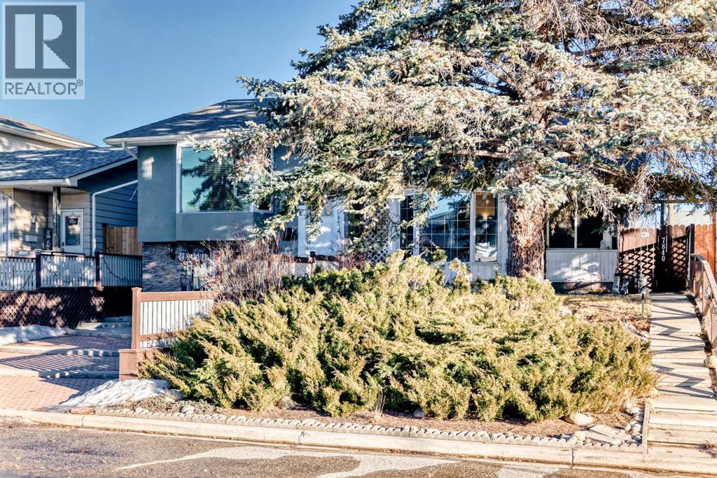 Landscaped and engulfed with a beautiful spruce tree - 7840 20A Street Se, Calgary, AB - Outdoor