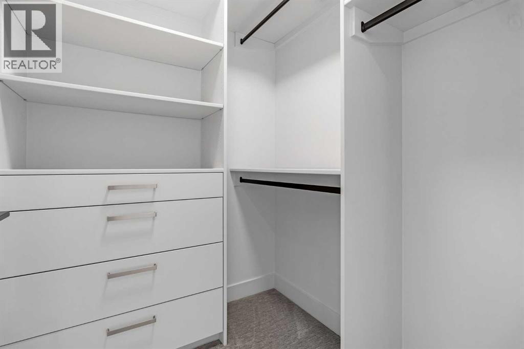 BEDROOM 2 WALK IN CLOSET - 340 West Chestermere Drive, Chestermere, AB - Indoor With Storage
