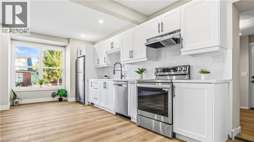 Kitchen featuring white cabinets, stainless steel appliances, light wood finished floors, backsplash, and recessed lighting - 491 Upper Wentworth Street, Hamilton, ON - Indoor Photo Showing Kitchen