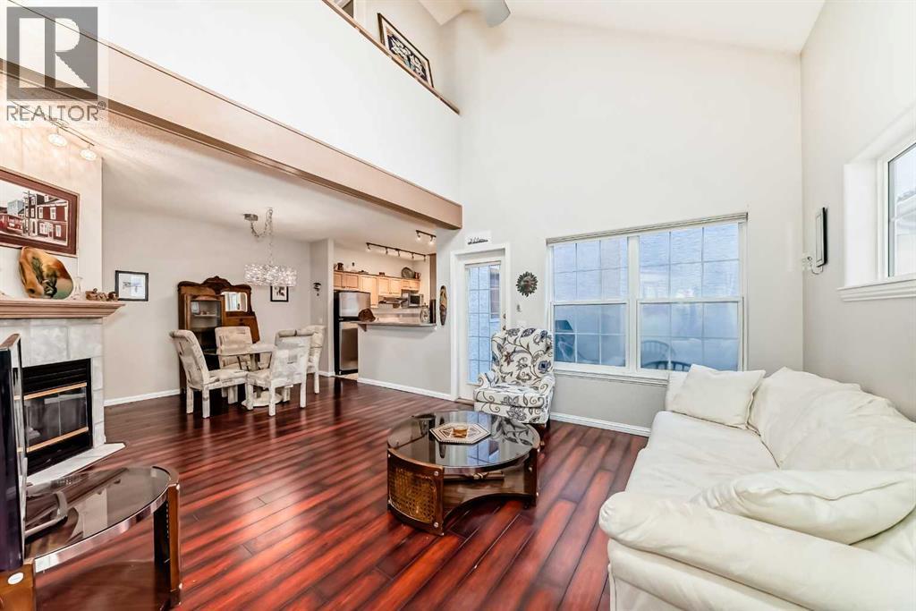 Living room looking toward dining room and kitchen - 1906 Patterson View Sw, Calgary, AB - Indoor Photo Showing Living Room With Fireplace