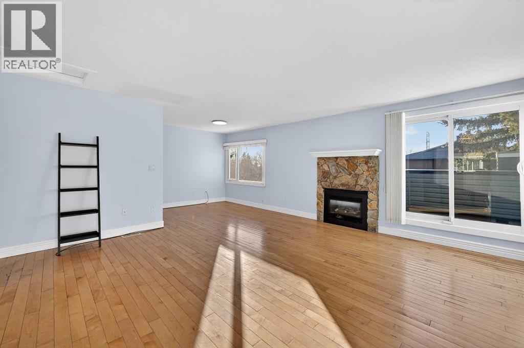 211, 25 Glamis Green Sw, Calgary, AB - Indoor Photo Showing Living Room With Fireplace