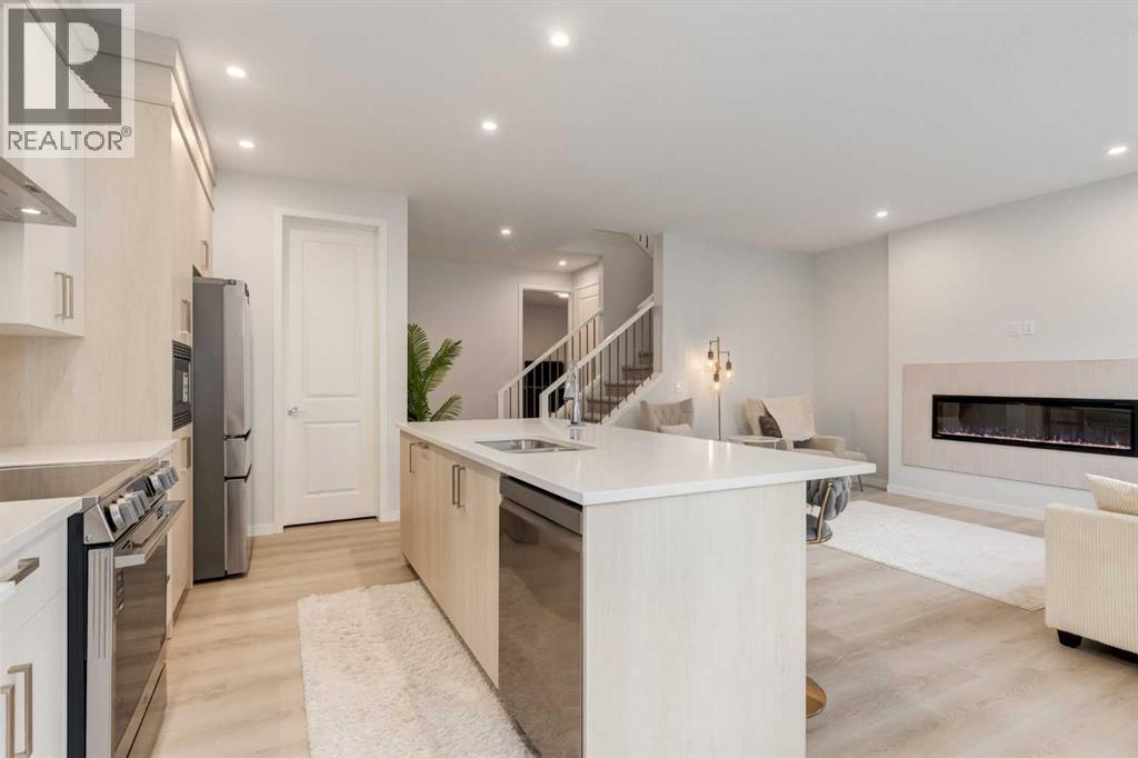 29 Marmot Passage Nw, Calgary, AB - Indoor Photo Showing Kitchen With Fireplace