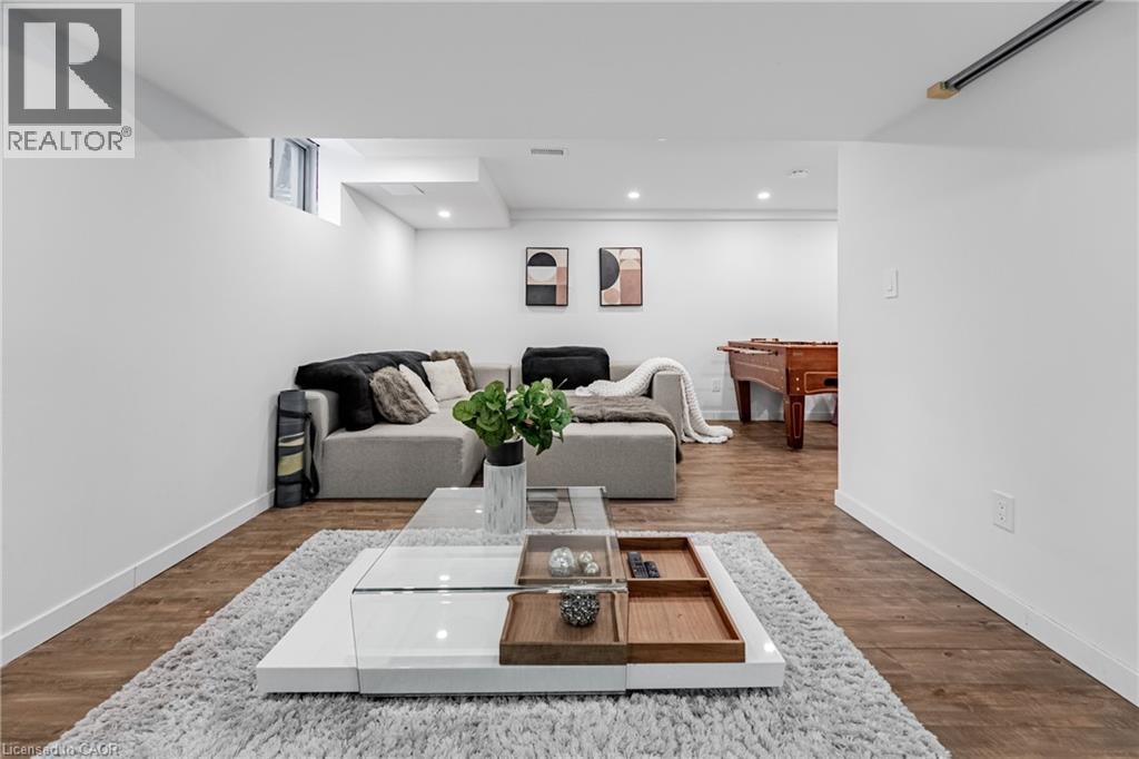 View of front of home featuring stone siding, stucco siding, a porch, and an attached garage - 5056 New Street Unit# 21, Burlington, ON - Indoor