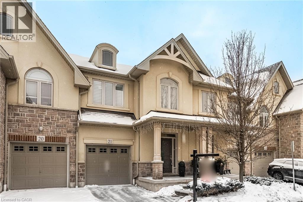 View of front facade featuring a porch, stone siding, stucco siding, and an attached garage - 5056 New Street Unit# 21, Burlington, ON - Outdoor With Facade