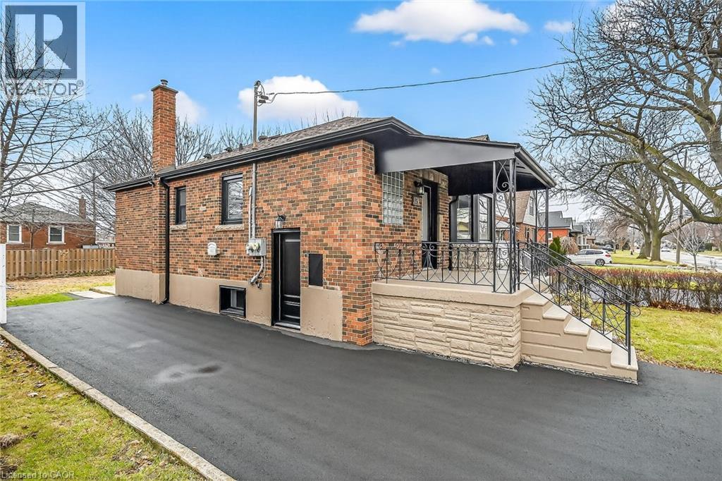 View of side of property featuring brick siding, a chimney, and a porch - 174 East 34Th Street, Hamilton, ON - Outdoor