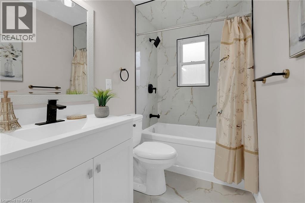 Full bathroom featuring vanity, light marble finish flooring, and a combined bath / shower with marble appearance - 174 East 34Th Street, Hamilton, ON - Indoor Photo Showing Bathroom