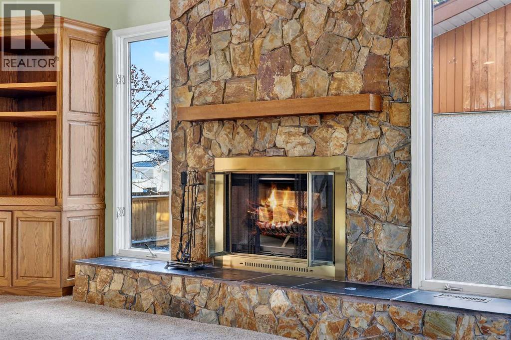 Natural Rock Wood Burning Fireplace with Log Lighter - 5315 Valiant Drive Nw, Calgary, AB - Indoor With Fireplace
