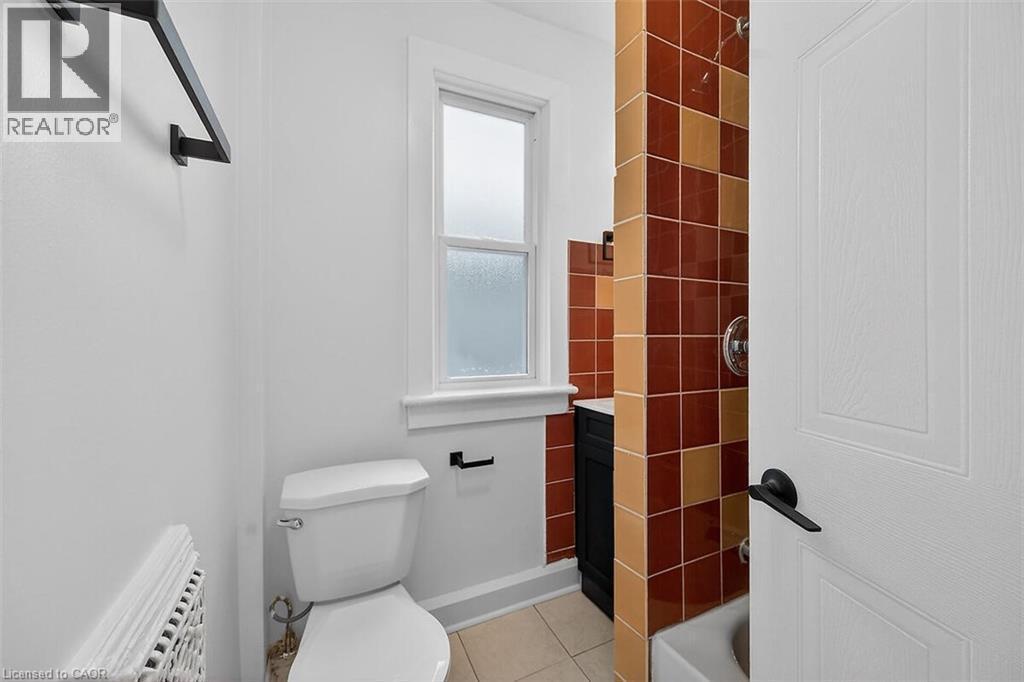 Bathroom featuring vanity, light tile patterned floors, and shower / tub combination - 77 Barton Street E Unit# 2, Hamilton, ON - Indoor Photo Showing Bathroom