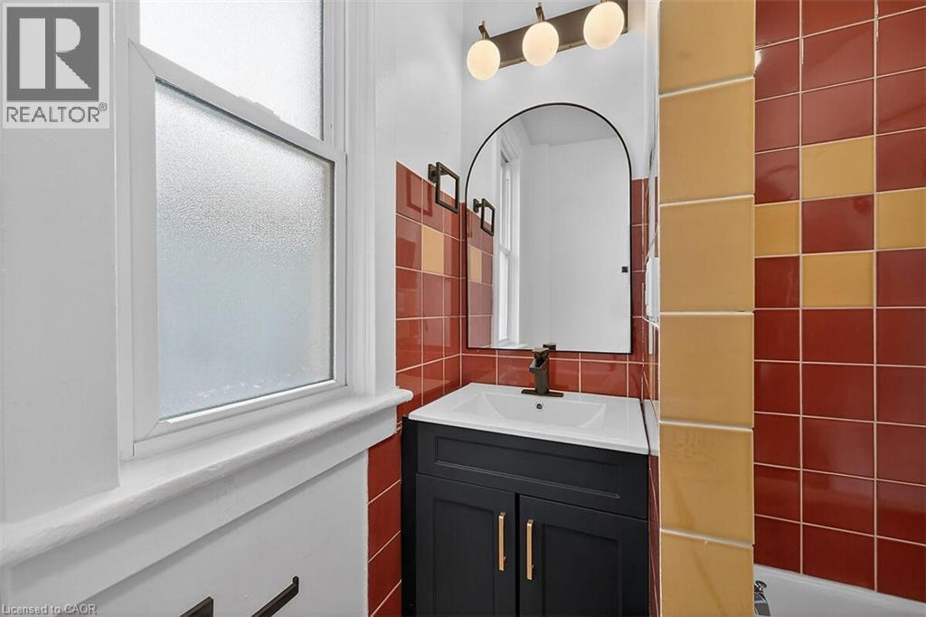 Bathroom featuring vanity and tile walls - 77 Barton Street E Unit# 2, Hamilton, ON - Indoor Photo Showing Bathroom