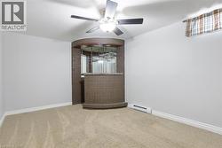 Spare room featuring ceiling fan, carpet, and a baseboard radiator -