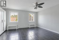Spare room featuring a baseboard heating unit, dark tile patterned flooring, and baseboards -