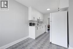 Kitchen with sink, white cabinetry, and white refrigerator -