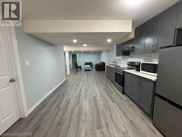 Kitchen featuring stainless steel appliances, light wood-style flooring, light countertops, open floor plan, and recessed lighting - 509 St Moritz Avenue Unit# Lower, Waterloo, ON - Indoor Photo Showing Kitchen
