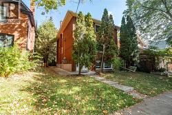 View of side of property with a lawn, brick siding, and a chimney -