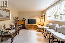 Living area with a glass covered fireplace and light tile patterned flooring -