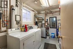 Shared laundry room featuring finished concrete flooring, separate washer and dryer, and water heater -
