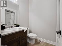 Bathroom with vanity, toilet, baseboards, a shower with curtain, and visible vents -
