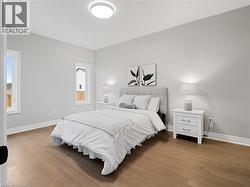 Bedroom with baseboards and wood finished floors -