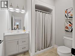 Bathroom featuring toilet, a stall shower, baseboards, and vanity -