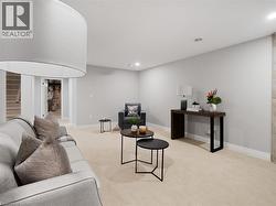Living room featuring recessed lighting, baseboards, light carpet, and stairway -