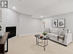Carpeted living room featuring recessed lighting, baseboards, and a tiled fireplace -