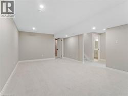 Finished below grade area with stairs, recessed lighting, baseboards, and light colored carpet -