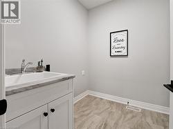 Laundry room featuring baseboards, visible vents, a sink, and marble finish floor -