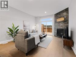Living room featuring recessed lighting, baseboards, wood finished floors, a tile fireplace, and visible vents -