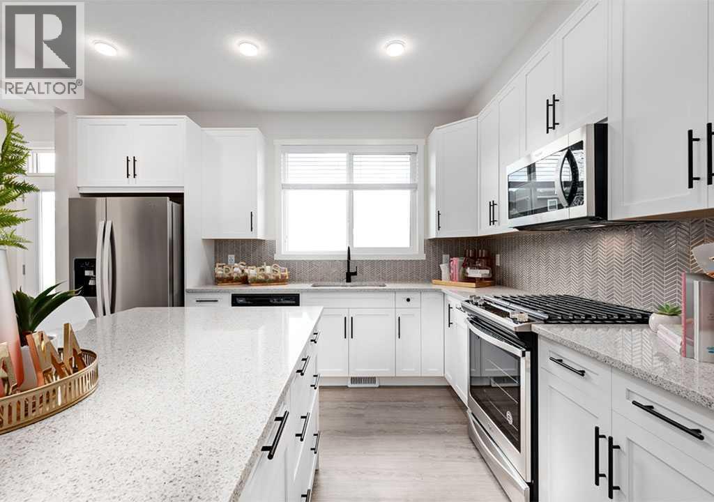 PLEASE NOTE: Photos are of a Showhome of the same model – fit & finish may differ. Interior selections & floorplans shown in photos - 162 Lanark Gate Se, Airdrie, AB - Indoor Photo Showing Kitchen With Upgraded Kitchen