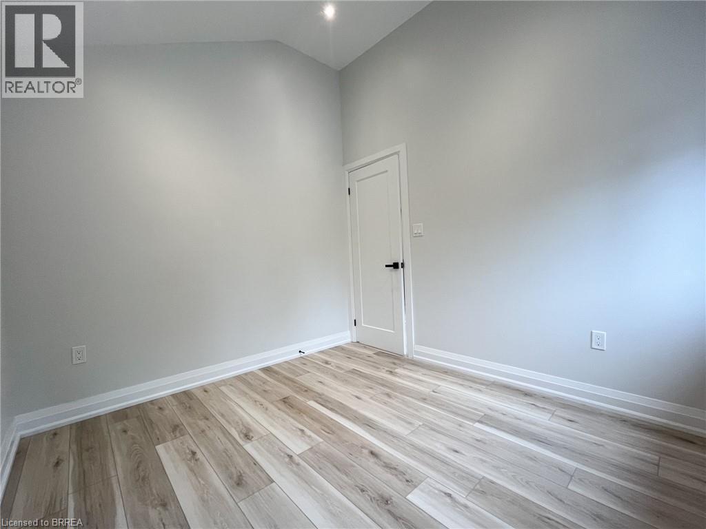 Spare room with light wood-style flooring and high vaulted ceiling - 110 Deschene Avenue, Hamilton, ON - Indoor Photo Showing Other Room