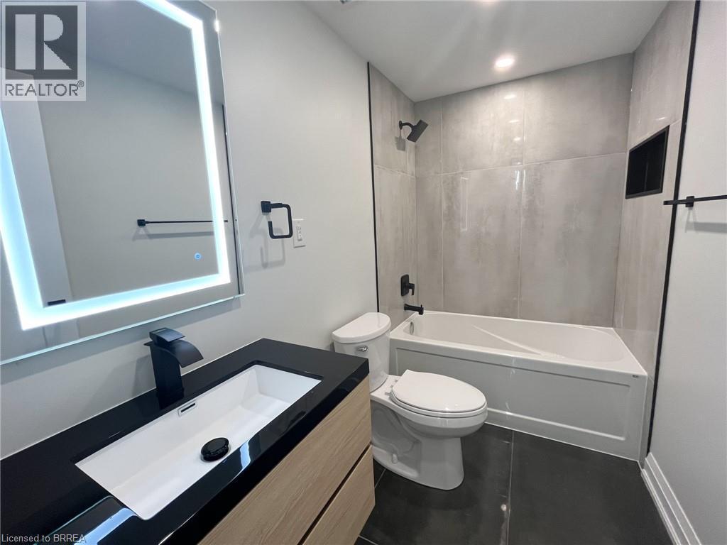 Full bathroom with shower / bath combination, vanity, dark tile patterned flooring, and recessed lighting - 110 Deschene Avenue, Hamilton, ON - Indoor Photo Showing Bathroom