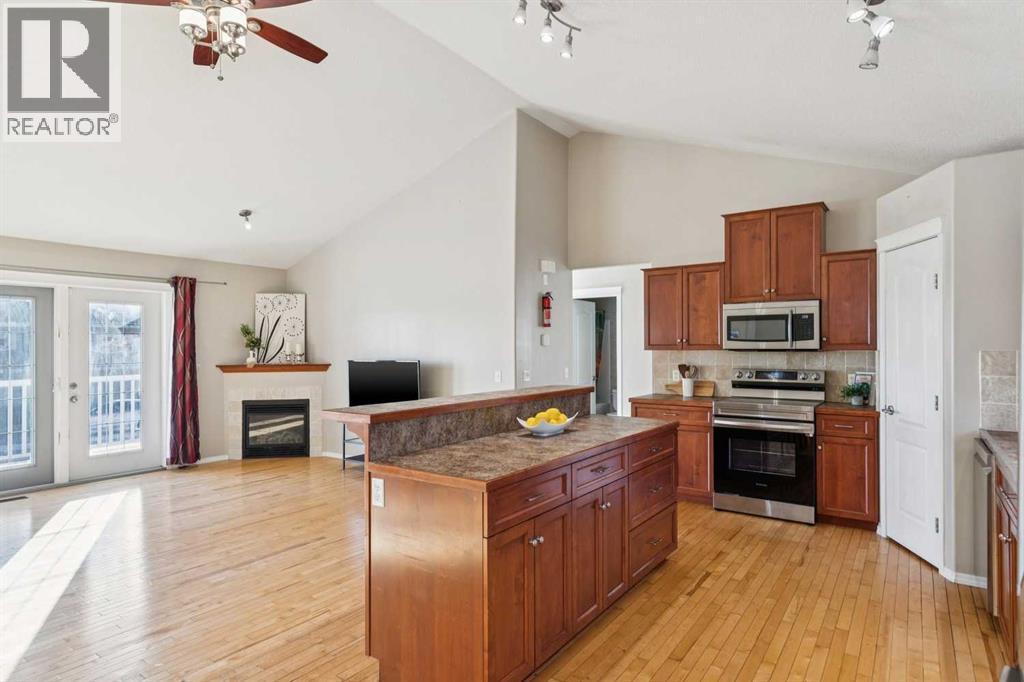 100B Westview Drive, Nanton, AB - Indoor Photo Showing Kitchen With Fireplace With Stainless Steel Kitchen