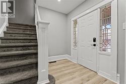 Foyer entrance featuring stairs and light wood finished floors -