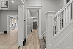 Hallway featuring stairs, light wood-style flooring, recessed lighting, and plenty of natural light -