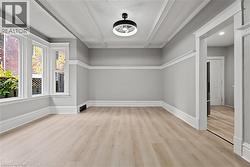 Additional living space with light wood-style floors and beamed ceiling -