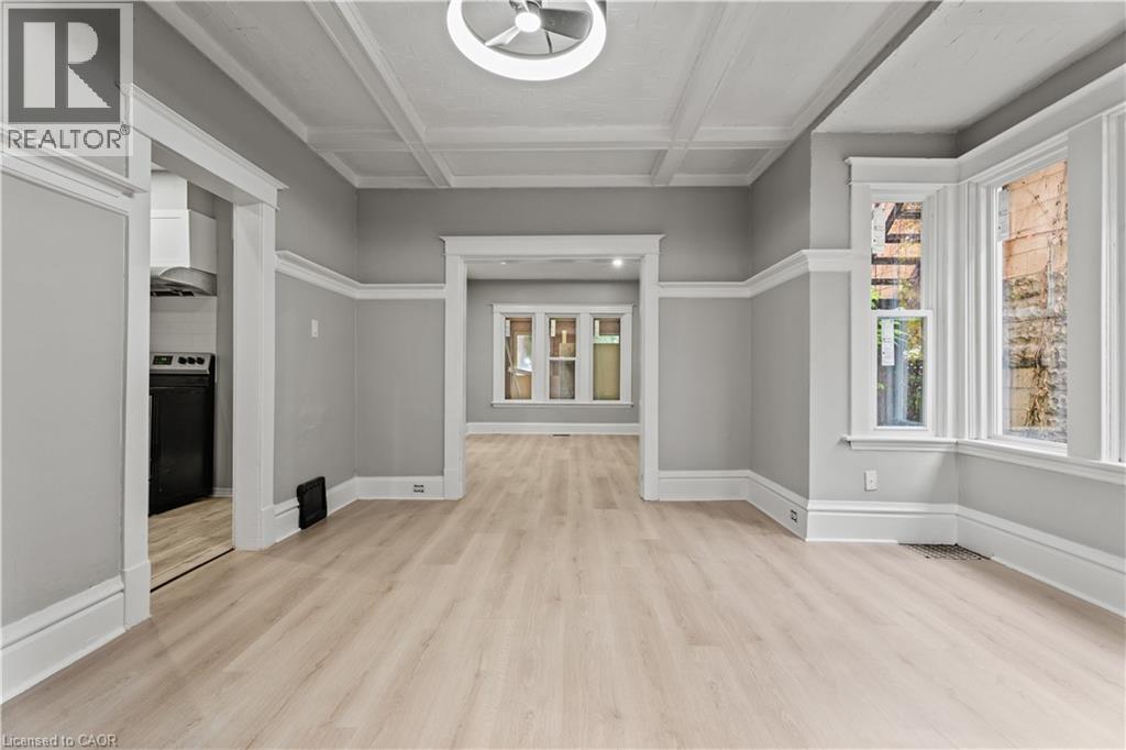 Unfurnished living room featuring coffered ceiling, light wood-type flooring, and beam ceiling - 88 Gage Avenue S, Hamilton, ON - Indoor Photo Showing Other Room