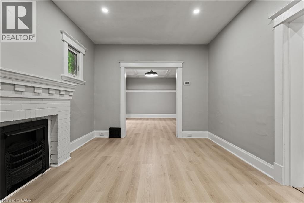 Unfurnished living room featuring light wood-style floors, a fireplace, and recessed lighting - 88 Gage Avenue S, Hamilton, ON - Indoor With Fireplace
