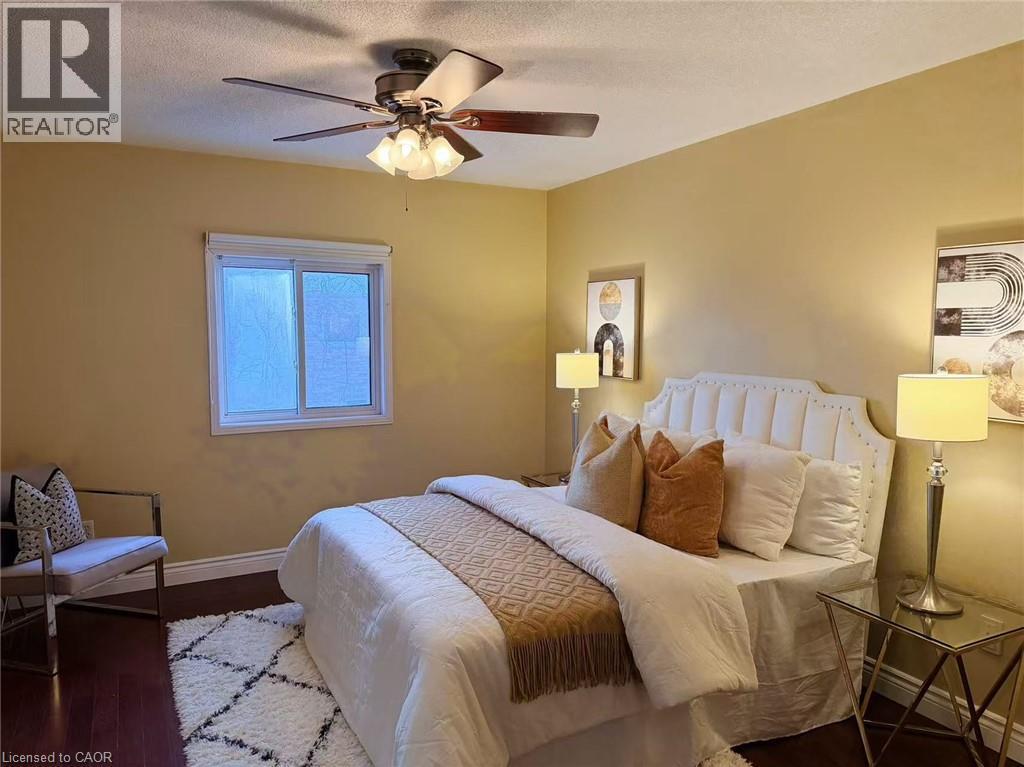 Bedroom featuring a textured ceiling, ceiling fan, and dark wood-style floors - 2258 Empire Crescent, Burlington, ON - Indoor Photo Showing Bedroom