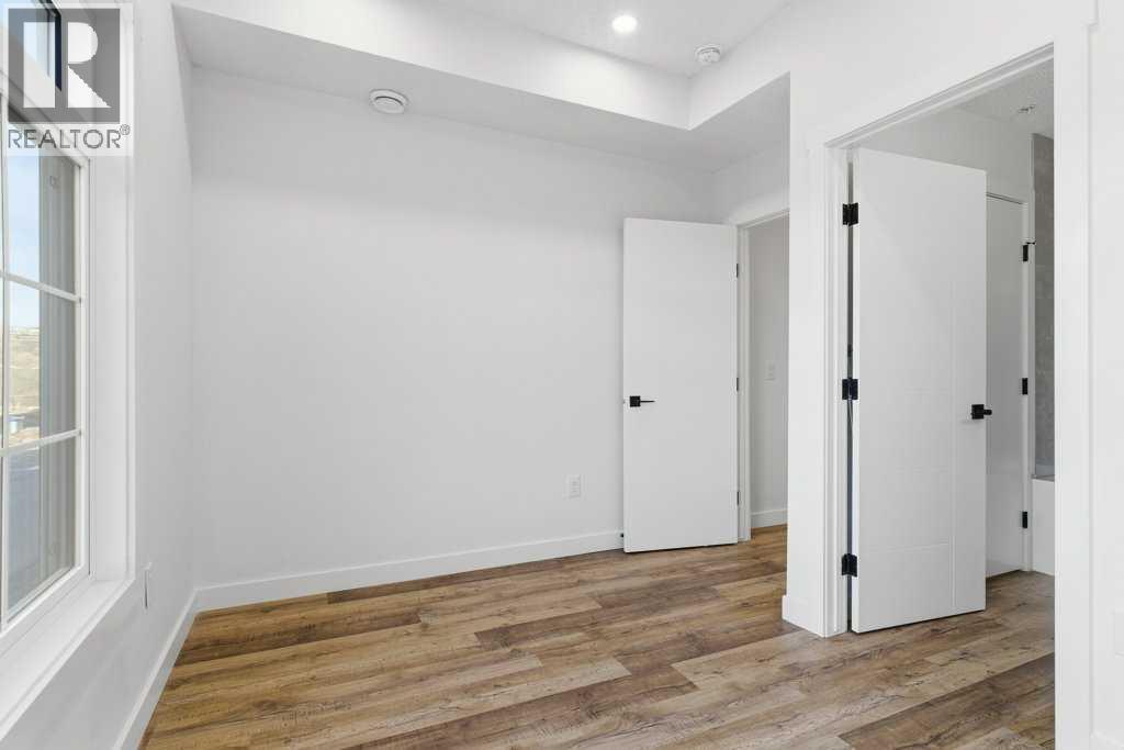 102, 156 Park Street, Cochrane, AB - Indoor Photo Showing Other Room