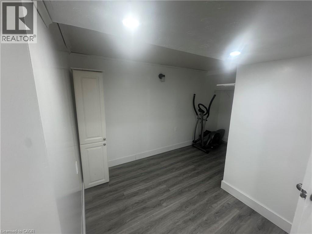 Unfurnished room featuring baseboards and dark wood finished floors - 18 Ingleside Drive, Kitchener, ON - Indoor