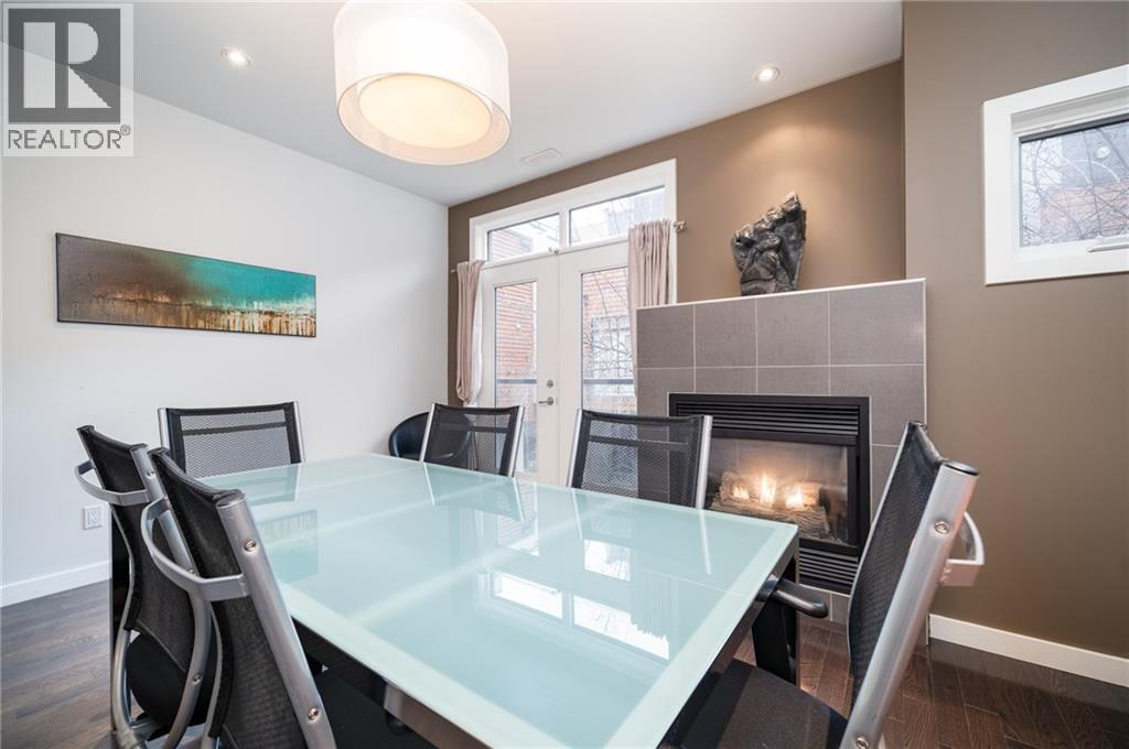 boardroom/family room - 1029 1 Avenue Ne, Calgary, AB - Indoor Photo Showing Dining Room With Fireplace