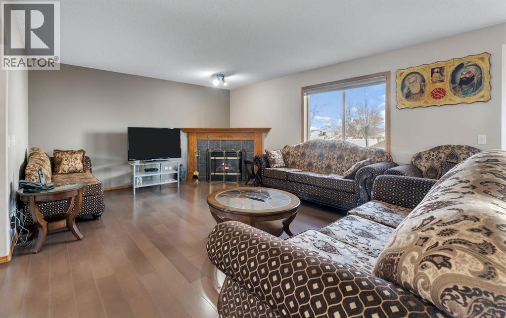 717 Coral Springs Boulevard Ne, Calgary, AB - Indoor Photo Showing Living Room With Fireplace
