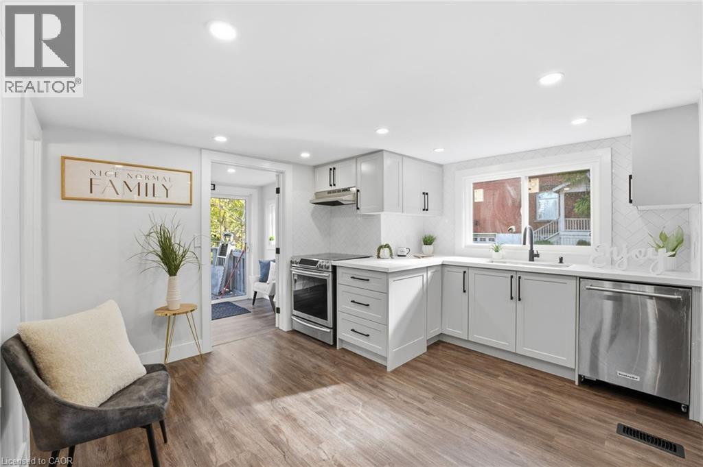 Kitchen featuring backsplash, stainless steel appliances, light wood-style floors, recessed lighting, and under cabinet range hood - 4255 William Street, Beamsville, ON - Indoor Photo Showing Kitchen With Upgraded Kitchen