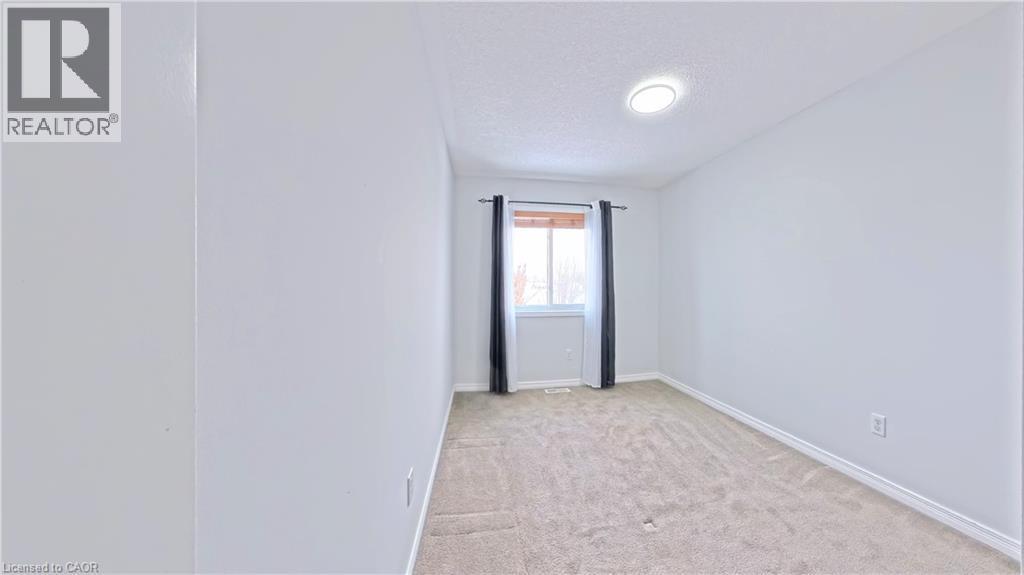 Unfurnished room featuring a textured ceiling and light colored carpet - 919 Zeller Crescent, Kitchener, ON - Indoor Photo Showing Other Room