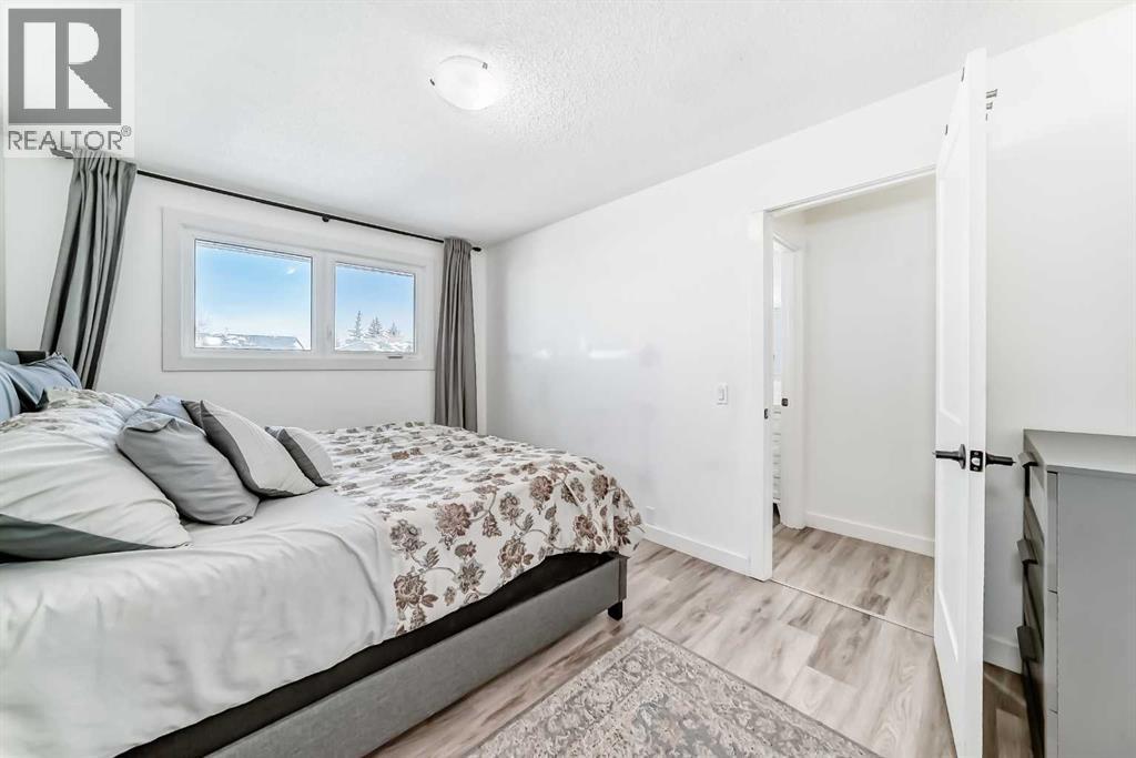 Primary bedroom window overlooks backyard - 216 Pinecrest Crescent Ne, Calgary, AB - Indoor Photo Showing Bedroom